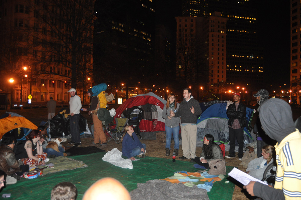 Occupy Atlanta members meet in the middle of Woodruff Park for their frequent General Assembly. Members use hand signals and timers to maintain order.