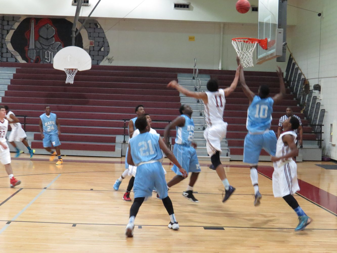 Both boys teams attempt to possess the rebound.