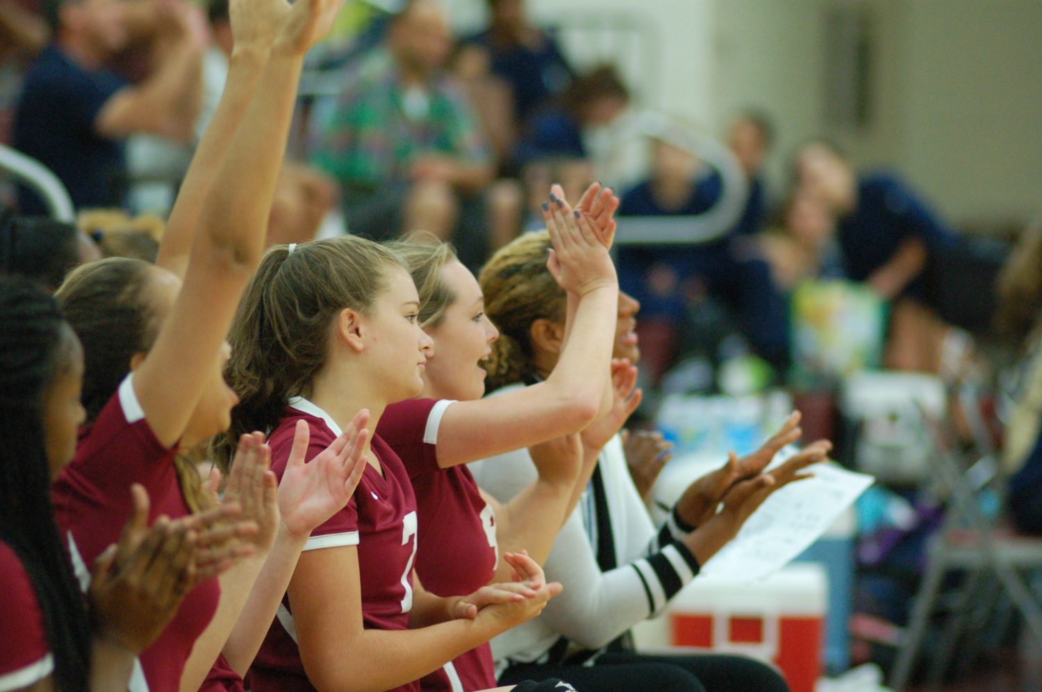 The junior varsity volleyball team cheers on their teammates during a match against Decatur High School.