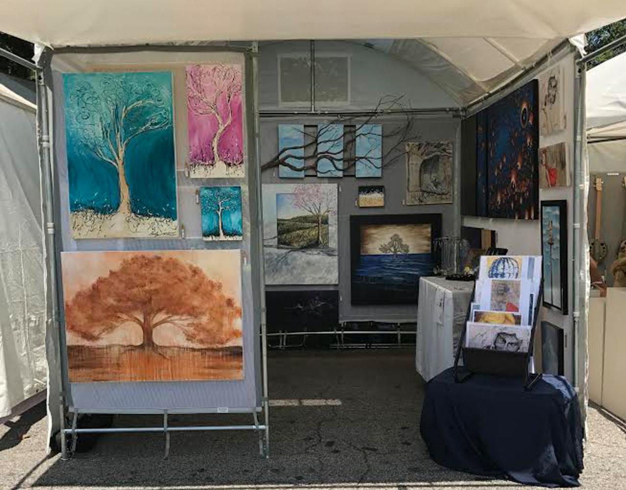 An artist displays his or her paintings at the Piedmont Park Arts Festival. Photo by Parker Killenberg.