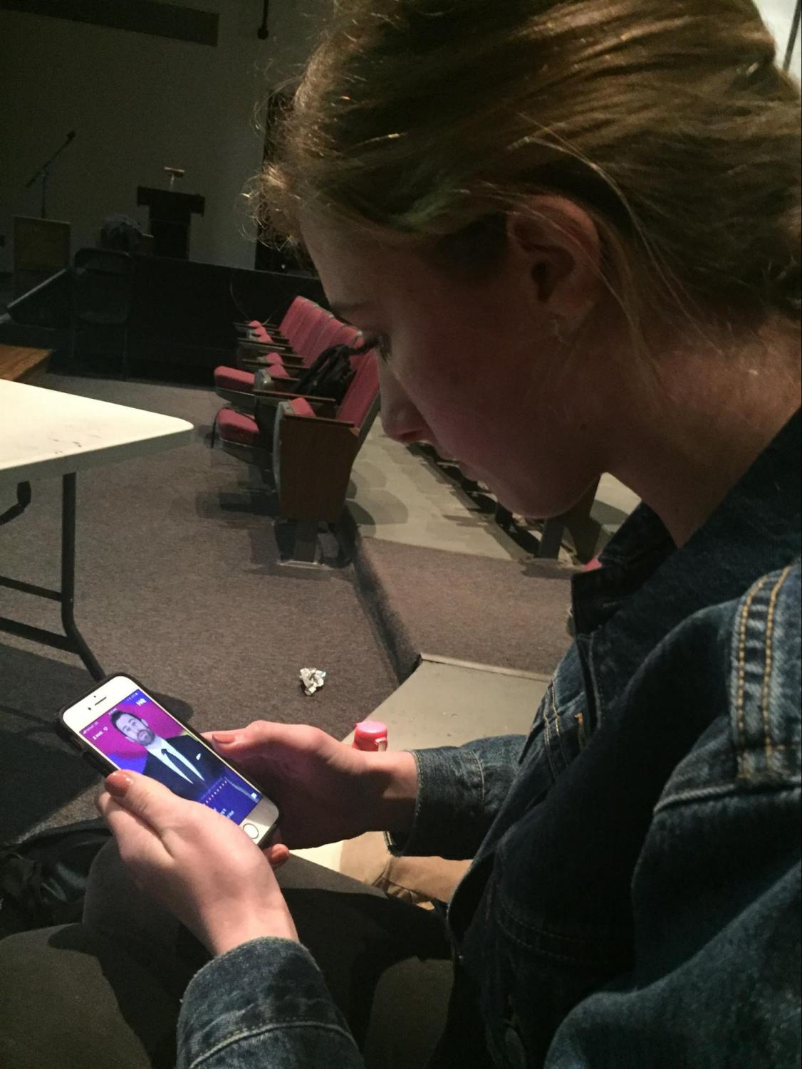 Junior Olivia Hunter pulls her phone out to play 'HQ' in the Vincent Murray Auditorium on Thursday, Jan 25, 2018. Hunter looks anxiously at the phone as Scott