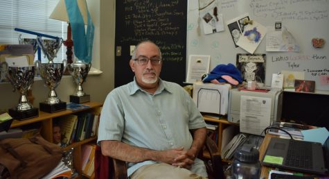 Mario Lorenzo Herrera sits in his iconic third floor classroom filled in view of hundreds of trophies and awards the debate team has won under his care. 