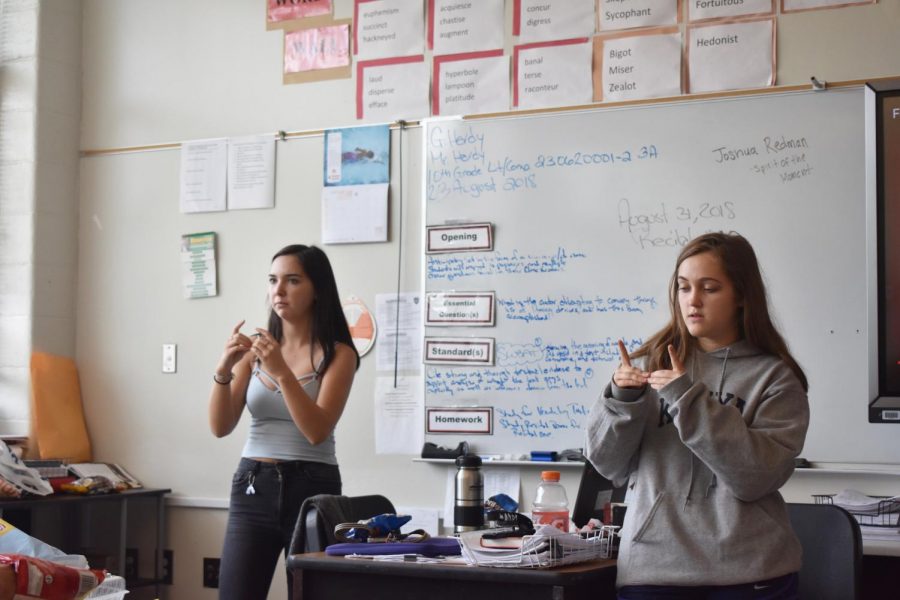 Juniors Liah Lawson (left) and Olivia Bransford teach sign language to members of the newly-created Sign Language Club. 
