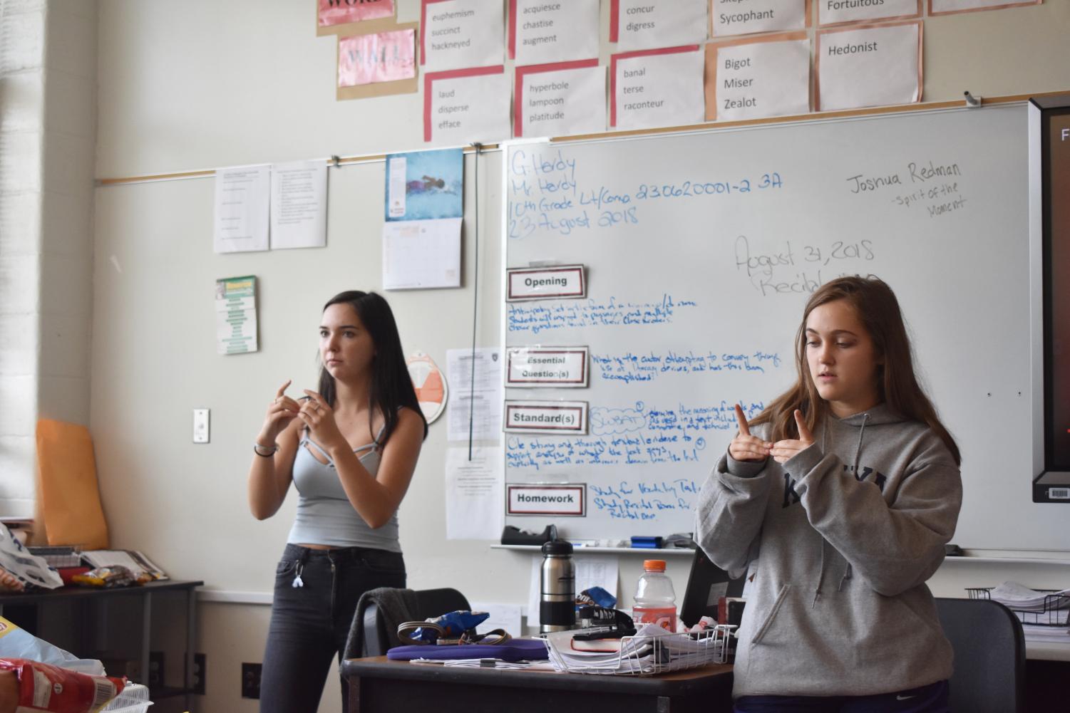 Juniors Liah Lawson (left) and Olivia Bransford teach sign language to members of the newly-created Sign Language Club.