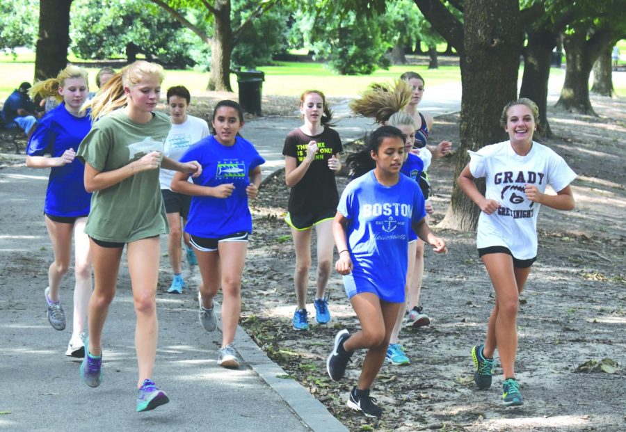 Speeding into the season: The girls cross country team runs through Piedmont Park during one of their afternoon training sessions.