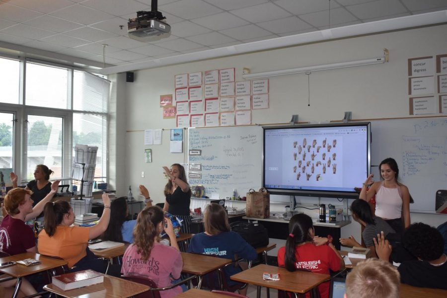 Club leaders Liah Lawson, Emily Schulz, and Olivia Bransford teaching the club members the alphabet in sign language. 