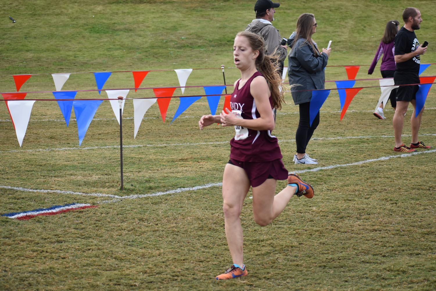 Senior Anna Tischer runs through the shoot into the finish at the state course in Carrollton. She placed second for Grady and 25th overall with a time of 21:16.59. This was Tischer's fourth and final state meet of her high school career.