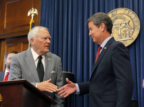 Former Secretary of State Brian Kemp (right) shakes hands with Georgia Governor Nathan Deal (left) on Nov. 8, as Kemp resigns from his position.