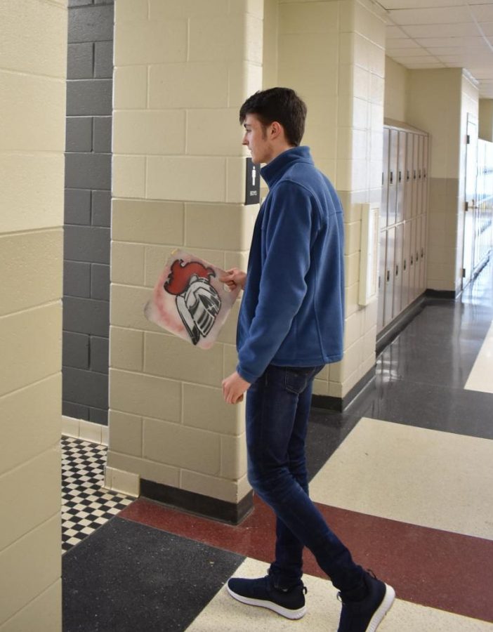 “Anything that goes into a restroom is super dirty, no matter what. Im completely grossed out about it,” said junior Isaac Turner, shown here carrying the pass into the restroom. 