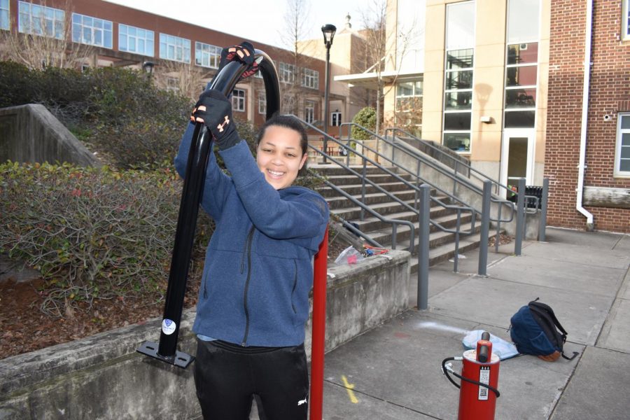Junior Bria Brown excitedly holding up a bike rack as the installation is halfway through.