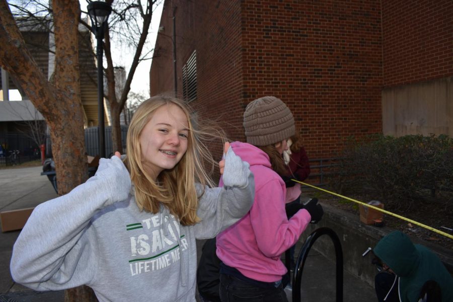 Freshman Audrey Isakov smiles through the pain of cold weather, with a smile on her face as the project is halfway through completion.