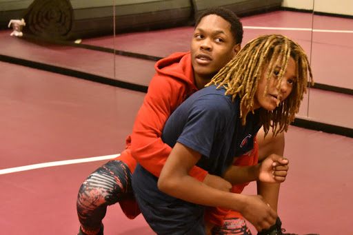 Freshmen Jakari Christian (left) and Malic Henderson (right) learn a new technique during wrestling practice. The team practices in the dance studio.