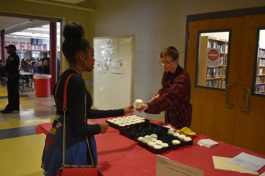 Senior Sylvia Price hands out cupcakes to students from homerooms who read the most during the Race2Read initiative.