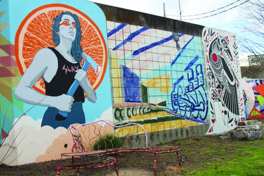 UNITING A COMMUNITY: In front of the “Forward Warriors” murals lie artistic benches made from squiggly patterns, each a different color, for people to sit and take in the art around them: the murals and nature across from the Esther Peachy Lefevre Park. The child and canine-friendly park was renovated in 2013, which added a new playground and dog water fountains.