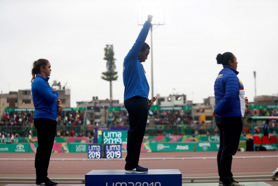 Team USA hammer thrower Gwen Berry holds her fist in the air during the national anthem after receiving a gold medal at the 2019 PanAm Games in Lima, Peru. As a result, Berry received 12 months of probation.