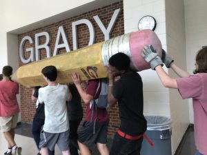 Tech theater students carried the pencil statue, symbolizing standardized testing, from the front lawn to the scene shop on Friday, August 23.