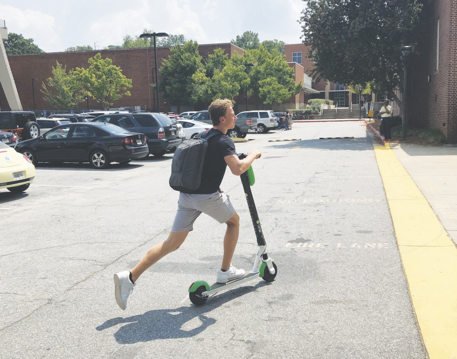 SCHOLASTIC SCOOTING: Senior Grant McNiff rides an e-scooter to school in the morning. Many Grady students opt to use this mode of transportation as their way to and home from school.
