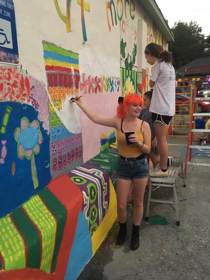 AP Art student Rose Nichols works on a mural at the Candler Park Market. The National Art Honor Society promotes opportunities such as these. 