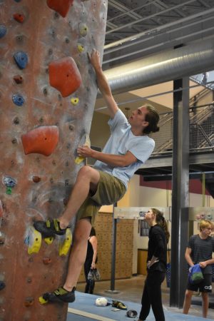 Senior Will Meyer climbs a bouldering route at Stone Summit before his shift starts. Meyer has been climbing since 9th grade, and is planning on going on a climbing trip to a cliff in Kentucky with fellow employees.