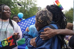 Isiah Ramsby and Gabrielle Merit, co-leaders of the GSA, hug as the parade marches on behind them. This is my first Pride, and Ive never felt so open about myself and comfortable,  Merit said. Its so loving and the environment is really nice.
