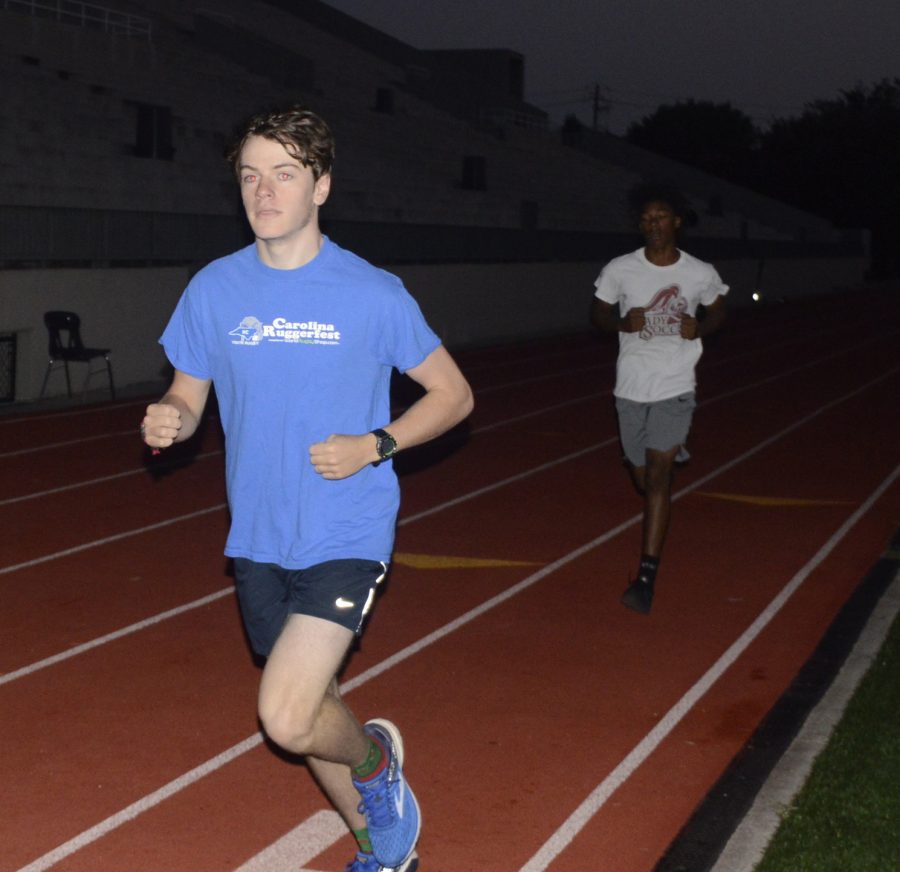 In a photo taken at a cross country morning practice in 2018, then juniors Ben Giersch and Keven Dorcinville run 400m repeats. Morning practices can be both beneficial and exhausting.