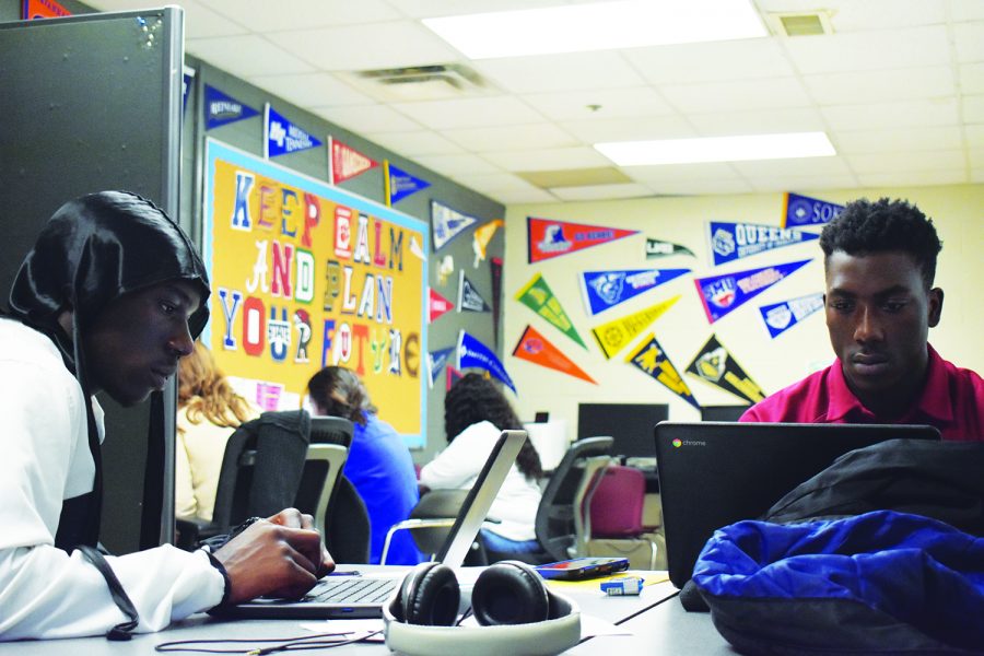 Seniors Melik Etienne (left) and Jason Nolton (right) spend third period working with college advisors Amber Jones and Abby Poirier in the college advisors office. On the wall is a a message reading Keep Calm and Plan Your Future which emphasizes the advisors mission that everyone will have a post-high school graduation plan. 