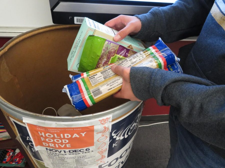 Helping the hungry: Sophomore Will Charlop donates food for the Grady Food Bank Clubs food drive. Dry goods and non-perishable items are accepted for the drive.