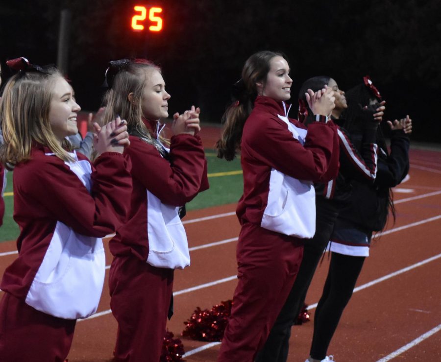 (Left to right) Junior Kristen Hart, senior Olivia Ledbetter and Junior Madigan Duncan cheer at the Knights’ last football game of the season on Nov. 9.