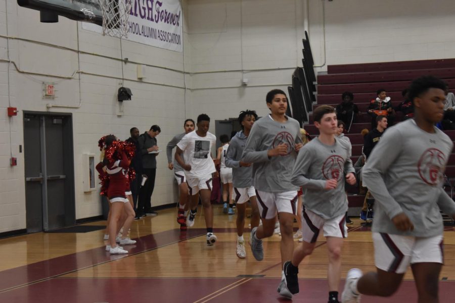 On January 11, 2020, the Varsity Boys basketball team took on KIPP at Grady. The boys are pictured running out of a tunnel of cheerleaders. After the game, their record was: 7-9.