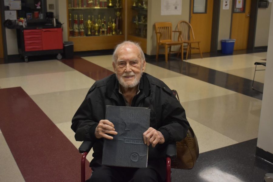 Tech High alum Ira Giles holds a yearbook from 1942, the year he graduated, while on a tour of Grady.