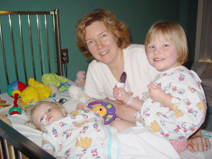Mother and organ donor, Elizabeth Moore, leans in toward her newly transplanted daughter, Helen Moore, alongside Helens sister in Nov. 2003.