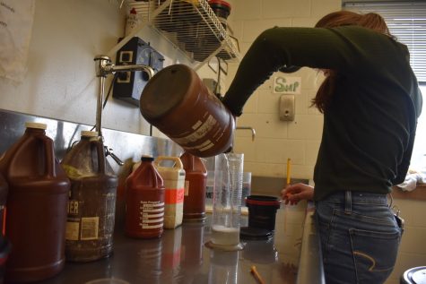 Sophomore and Photo II student Evelyn Lowry measures the amount of stop bath needed to develop her film. In the film developing process, a stop bath works as an acid to neutralize the effects of a   base, in this case developer.  

