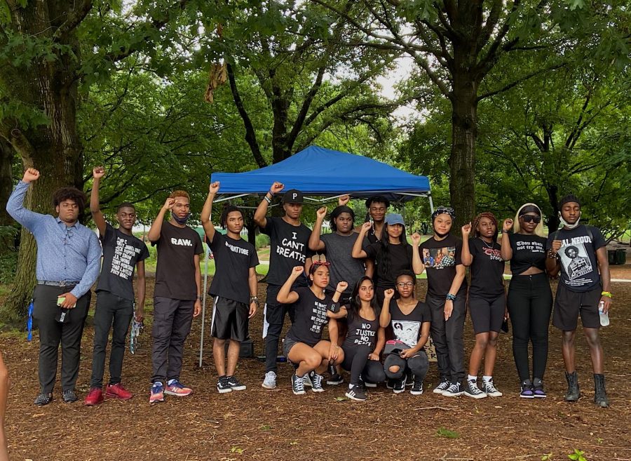 TLFC members pose with their right fist in the air. The fist is a symbol of solidarity with the black community.