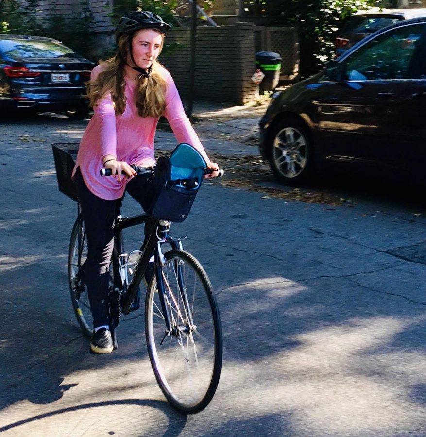 Junior Nora Ball rides her bike down a street. She is participating in Biketober, an event spanning the month of October, that encourages people to bike as much as possible.