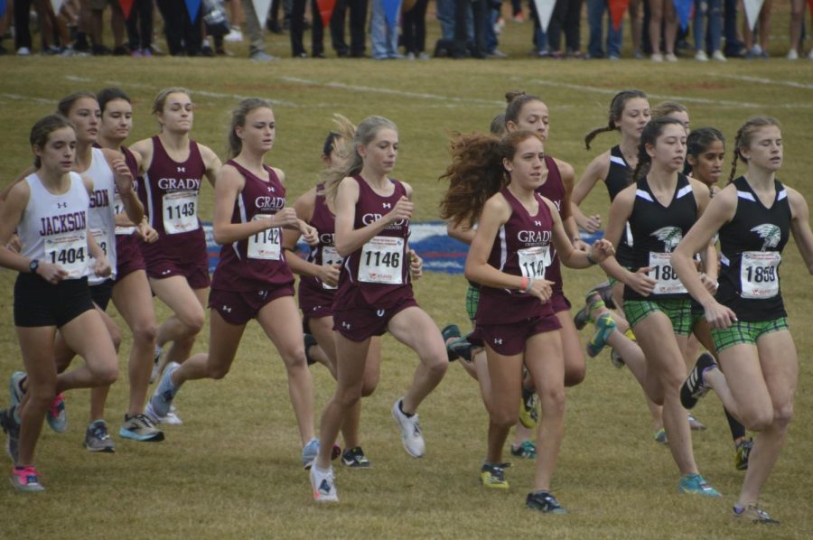 Seven members of the Grady girls cross country team sprint from the starting line of the state meet at Carrollton. They finished in ninth place. From left: sophomores Sarah Prevost and Aden Mikus, juniors Keira Ely, Zoe Chan and Ellie Spears and sophomores Emilia Weinrobe and  Jamie Marlowe. 