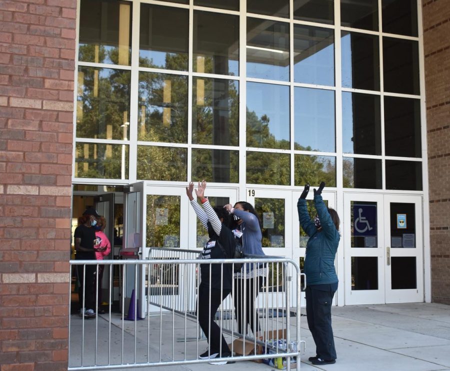 Poll workers at Bunche Middle School cheer on voters. 