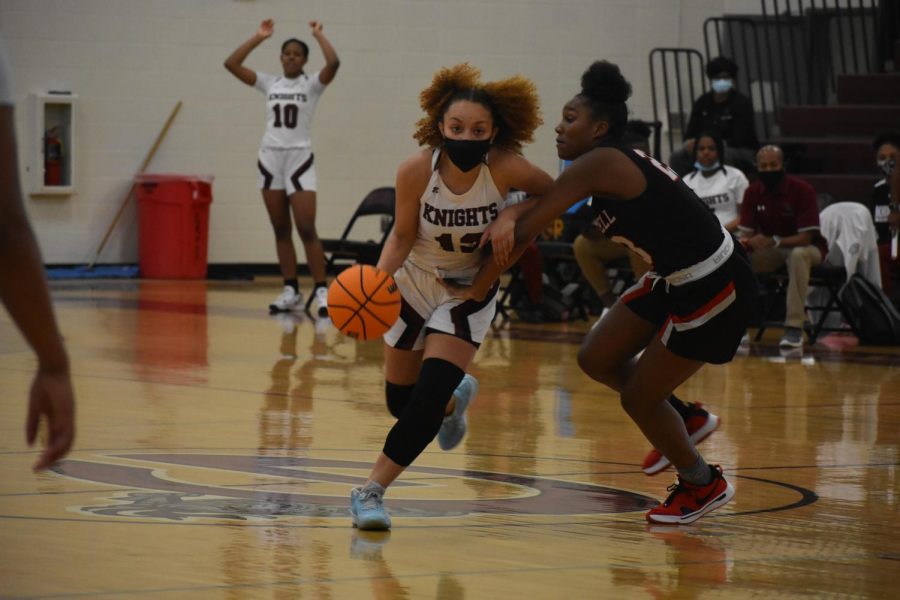 Senior Trinity Lewis pushes the ball up court in the first half as the Knights expand their lead against Therrell High School on Nov. 24.