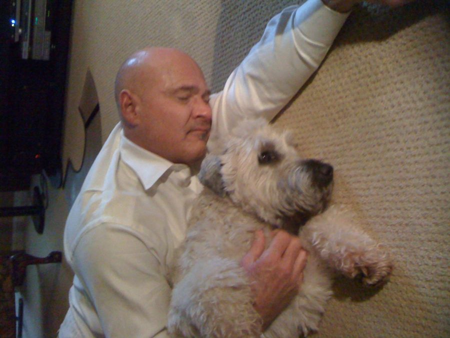 Dr. Bird lays with his Wheaton Terrier, Sutherland, named after Birds therapist.