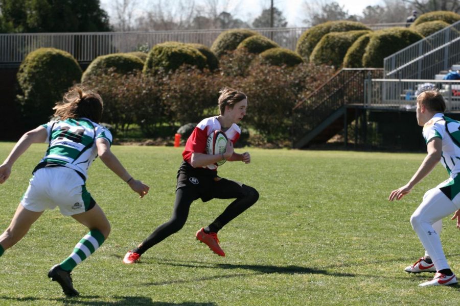 Abbott is seen running with the ball in a match. Abbott started playing rugby in seventh grade.