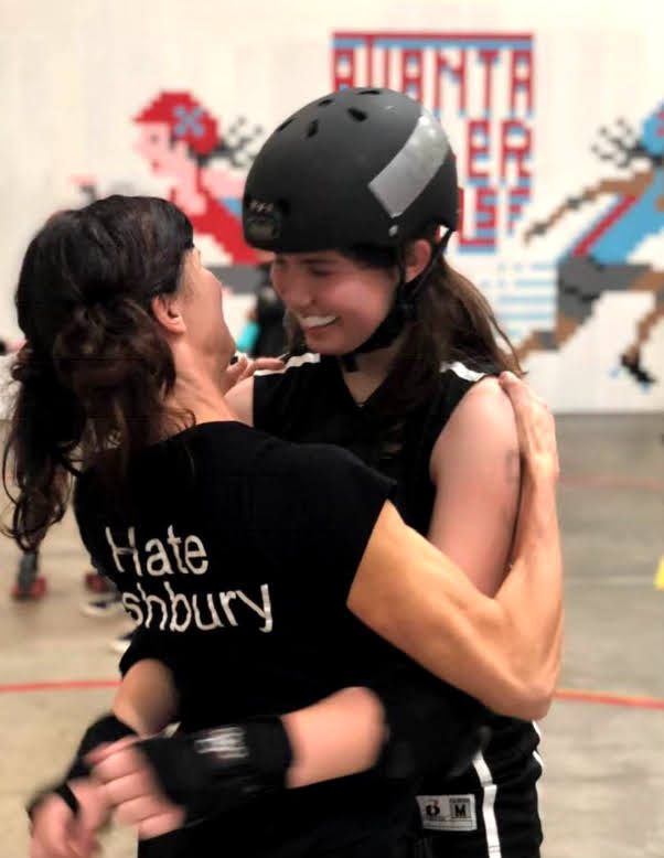 Brattain (right) hugs her mother after a roller derby match. 