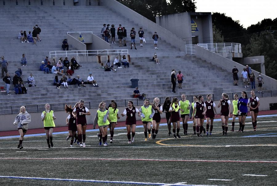 The Grady girls varsity soccer team celebrates their win with the entire team taking a half-lap around the field.