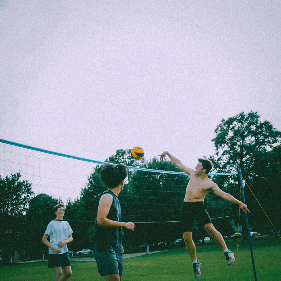 Senior Aiden Scarano leaps to spike the volleyball on the opposing teams side of the net at a meeting for volleyball club in Piedmont Park.