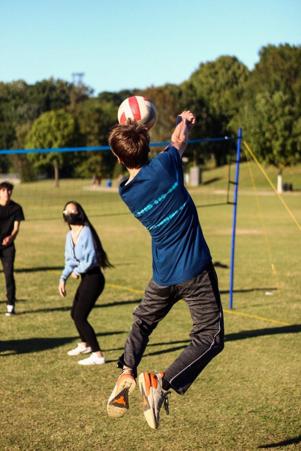 Senior Sam Barclay reaches to bump a ball back to the other side of the net at a meeting for volleyball club in Piedmont Park.