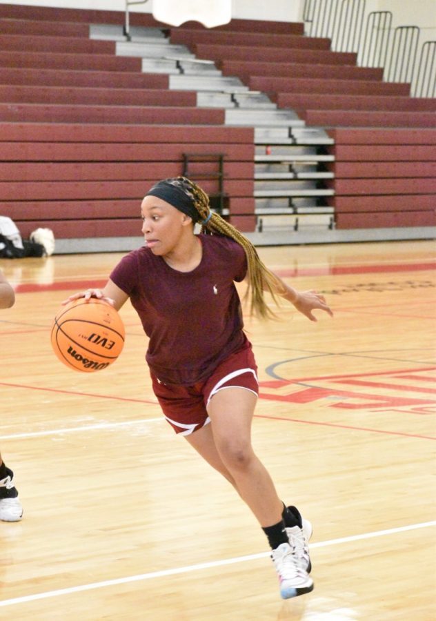 Senior Megan Nunn focuses during basketball tryouts as she eyes the basket before making a shot.  