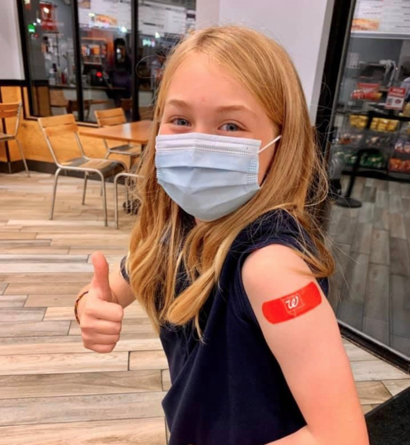 ON THE COUNT OF THREE: 8-year-old Carden Heuser gets her Covid-19 shot. “She  ran to get the shot and told strangers how excited she was,” parent Marie Martin said.
