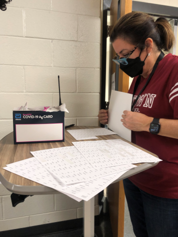 School bookkeeper Alex Coffman checks students in for surveillance testing. According to district policy, teachers and staff are tested twice weekly while students who have a signed permission form are tested twice-weekly.