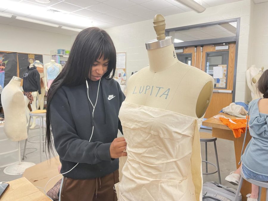 Senior Olivia Phillips constructs an outfit for the upcoming fashion show The Void. The show is set to premiere on April 20 and feature student designs and models for the community.