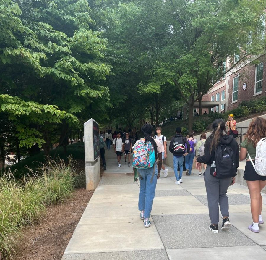 Students walk outside the C building during a transition.