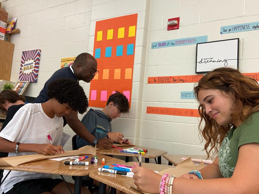 English teacher Alex Wallace helps freshmen Cameron Collier, Emily Stevens, and Grady Richman in class. This week, a new class of freshmen students began high school.