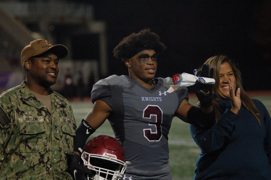 Senior Jordan Taylor walking out with his mother on Senior night against Stone Mountain on Oct. 28.